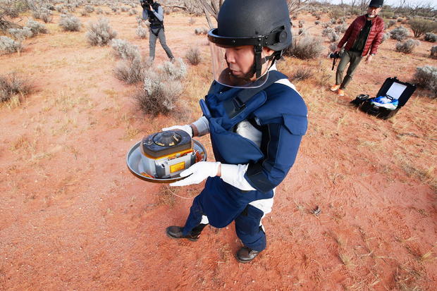 A member of JAXA collects Hayabusa2's capsule carrying the first extensive samples of an asteroid after it landed in the Woomera restricted area 