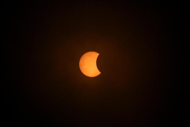 A solar eclipse is pictured during a cloudy day, in Villarrica 