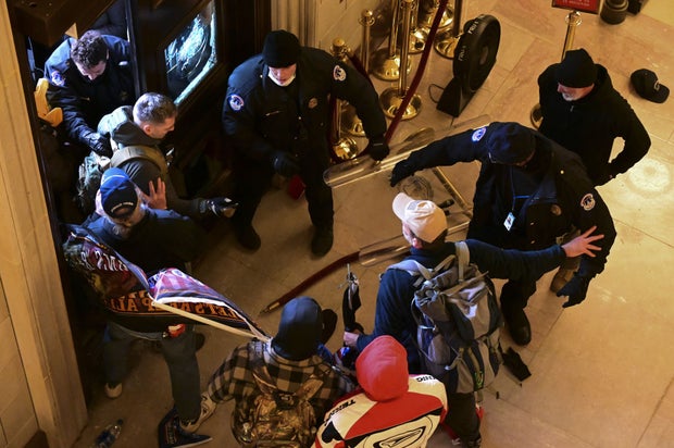 Demonstrators breach a door of the U.S. Capitol as a joint session of Congress counts the votes of the 2020 presidential election on Wednesday, Jan. 6, 2021.
