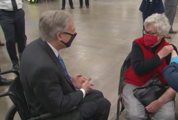 Gov. Greg Abbott visits with a woman getting the COVID-19 vaccination 