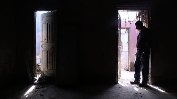 Man silhouetted in damaged home in Honduras 
