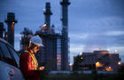 Petrochemical engineers work slowly and heavily with smart tablets in the oil and gas industry at night. 