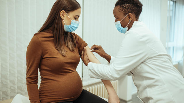 doctor preparing a pregnant woman for vaccination 