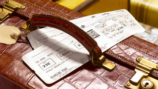 crocodile skin suitcase and boarding pass 