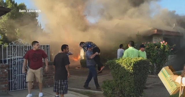 Man carried to safety as home goes up in flames - CBS News