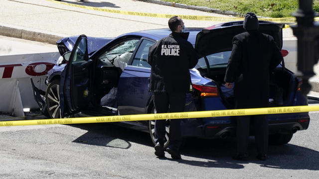 U.S. Capitol Police officers stand near a car that crashed into a barrier on Capitol Hill in Washington April 2, 2021. 