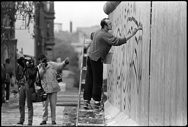 Actor Keith Haring painting the wall nearby Checkpoint Charlie. West-Berlin 1986