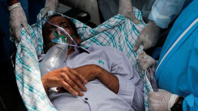 A patient suffering from the coronavirus disease (COVID-19) is evacuated from a hospital after it caught fire in Virar, on the outskirts of Mumbai 