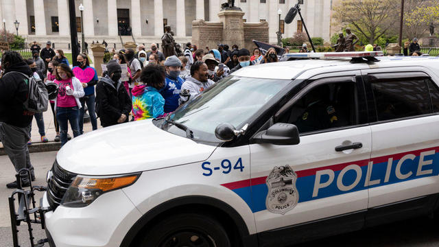 Columbus Police cruisers round the Ohio Statehouse interact 