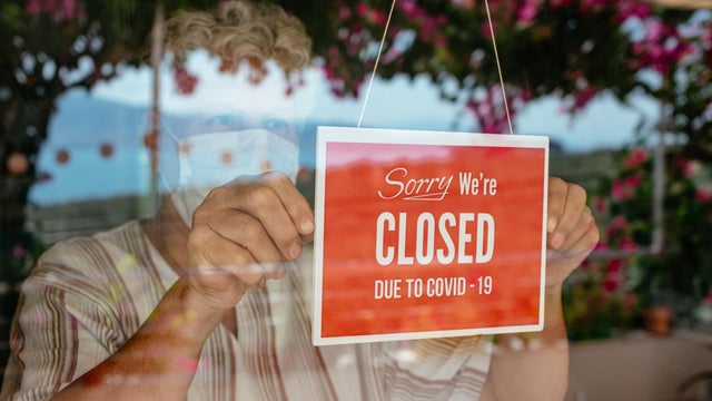 Business Owner With Face Mask Putting Closed Sign 