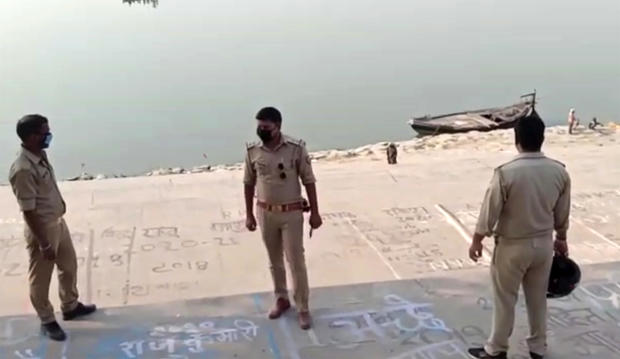 This frame grab from video provided by KK Productions shows police officials stand guard at the banks of the Ganges River, where several bodies were found, in Ghazipur district in Uttar Pradesh state, India, May 11, 2021. 