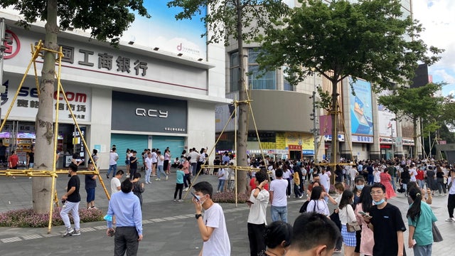 People gather outside the 73-storey SEG skyscraper in Shenzhen