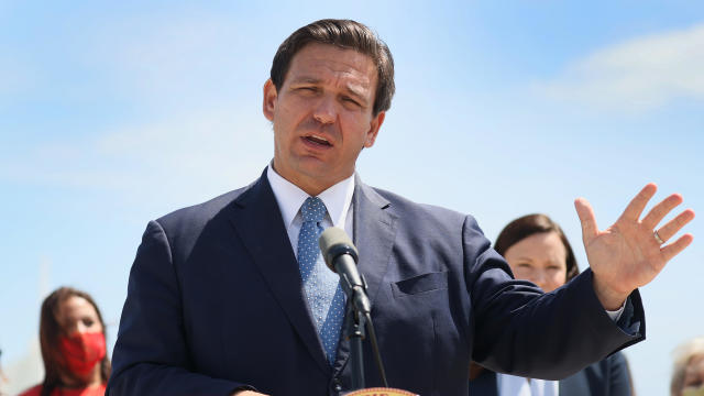 Florida Governor, Ron DeSantis listens to another speaker at 