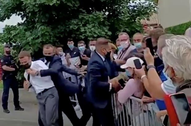 French President Emmanuel Macron is protected by a bodyguard after getting slapped by a member of the public during a visit in Tain-L'Hermitage, France, in this still image taken from video on June 8, 2021. 