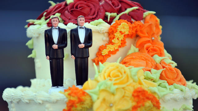 A wedding cake with statuettes of two me 