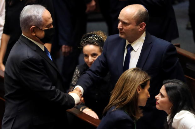 Head of Oposition Benjamin Netanyahu and Israel Prime minister Naftali Bennett shake hands following the vote on the new coalition at the Knesset, Israel's parliament, in Jerusalem 