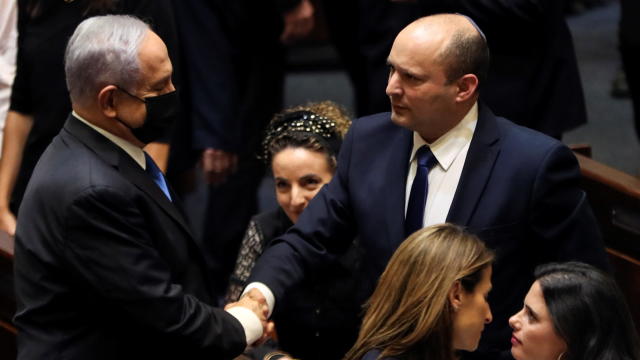 Head of Oposition Benjamin Netanyahu and Israel Prime minister Naftali Bennett shake hands following the vote on the new coalition at the Knesset, Israel's parliament, in Jerusalem 