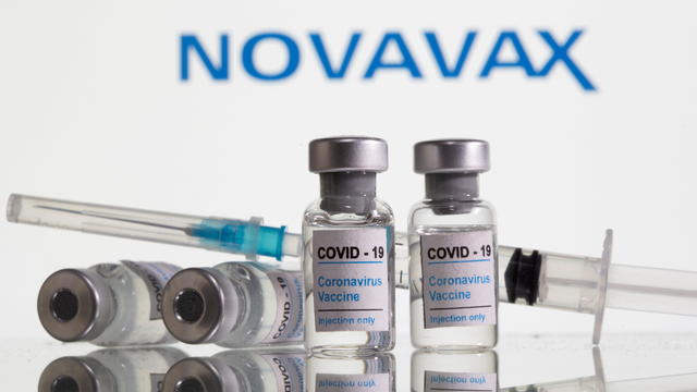 FILE PHOTO: Vials labelled "COVID-19 Coronavirus Vaccine" and syringe are seen in front of displayed Novavax logo in this illustration 
