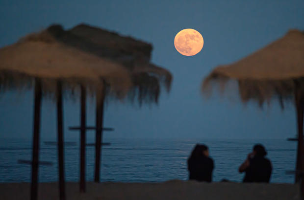 The full super moon rising over Malagueta beach.According 