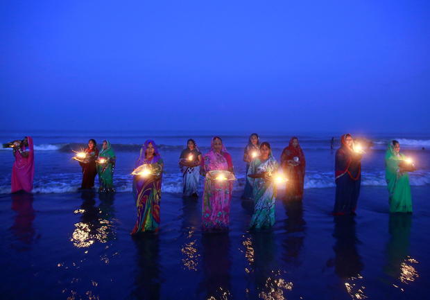 FILE PHOTO: Hindu devotees pray while standing in the waters of the Arabian Sea as they worship the Sun god Surya during the Hindu religious festival "Chatt Puja" in Mumbai 