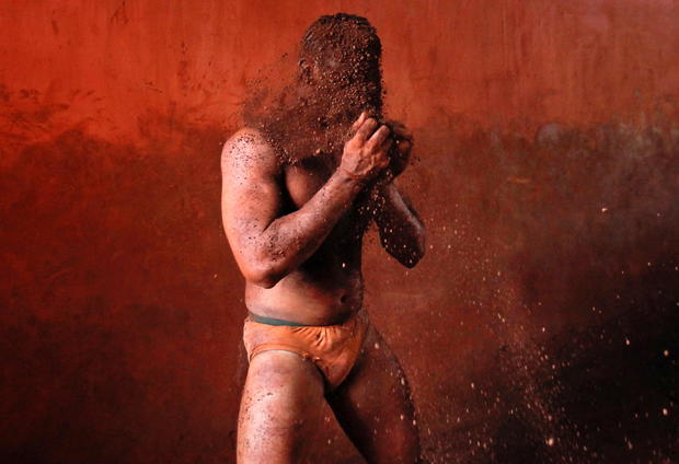 FILE PHOTO: A wrestler rubs his hands with mud to prevent slipping due to sweat, during a traditional mud wrestling bout in Kolhapur 