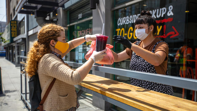 Woman Wearing Homemade Mask Picks Up Food at Restaurant During Covid-19 Lockdown 