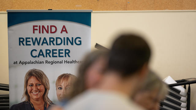 A sign inside a job fair reads "Find a rewarding career" 
