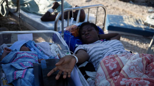A woman on a stretcher is pictured with a baby after a 7.2 magnitude earthquake in Les Cayes 
