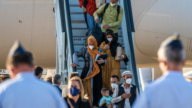 Afghan people disembarking from the last plane with evacuees 