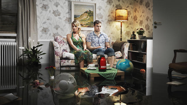 young couple in sofa in a flooded room 