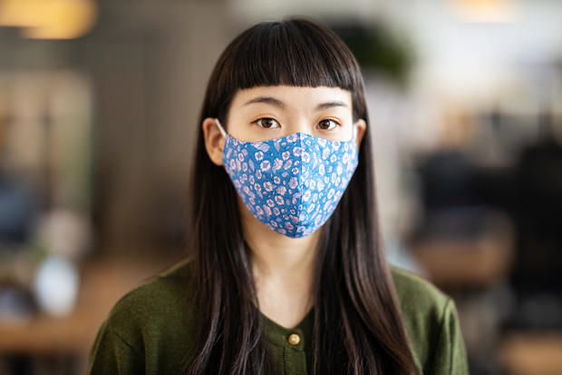 Businesswoman with face mask after returning back to work at office 