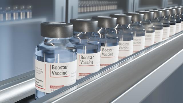 Vials of booster vaccine on conveyor in pharmaceutical factory 