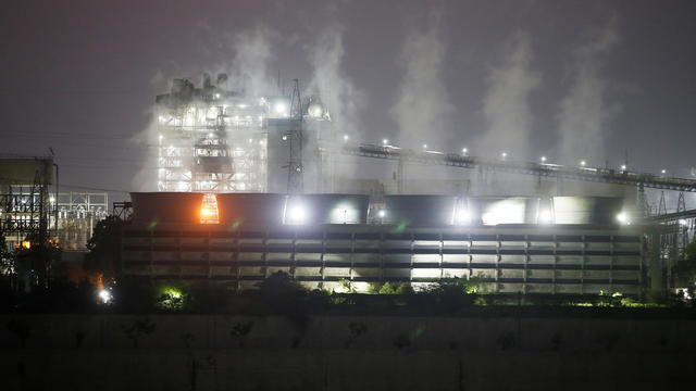 Smoke billows from the cooling towers of a coal-fired power plant in Ahmedabad 