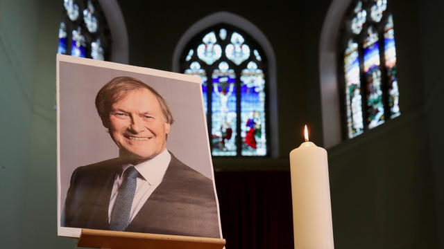 A candle and a portrait of British MP David Amess are seen at the church of St Michael's and all Angels, in Leigh-on-Sea 