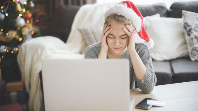 young woman in christmas interior with laptop  ( negative emotions) 