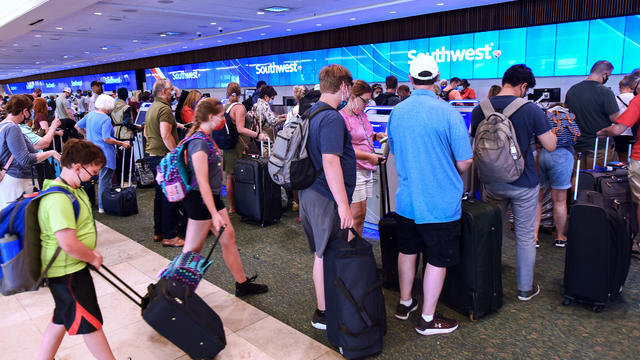 Travelers wait in line to check in at the Southwest Airlines 