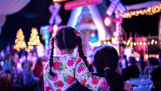 Mother and child are waiting for Santa at a Christmas tree lighting ceremony. 