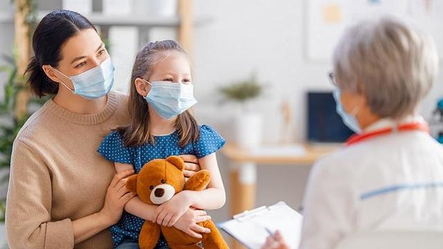 Doctor, child and mother wearing facemasks 