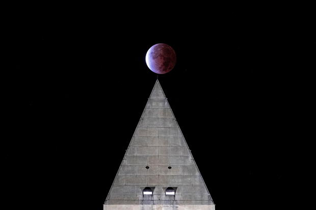 The partial lunar eclipse is seen above the Washington Monument in Washington 