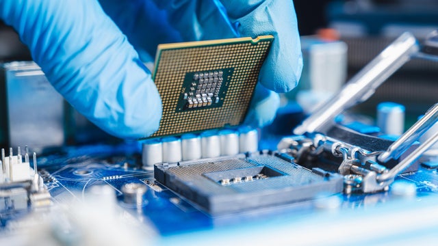 the technician laying CPU in the motherboard socket