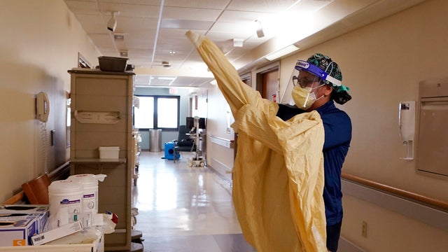 Registered nurse Monica Quintana dons protective gear before entering a room at the William Beaumont hospital April 21, 2021, in Royal Oak, Michigan. 