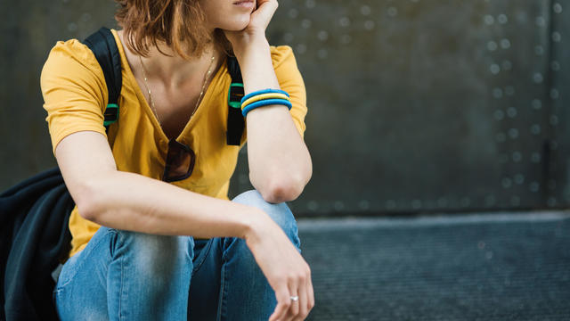 Depressed teen girl smoking on stairs 