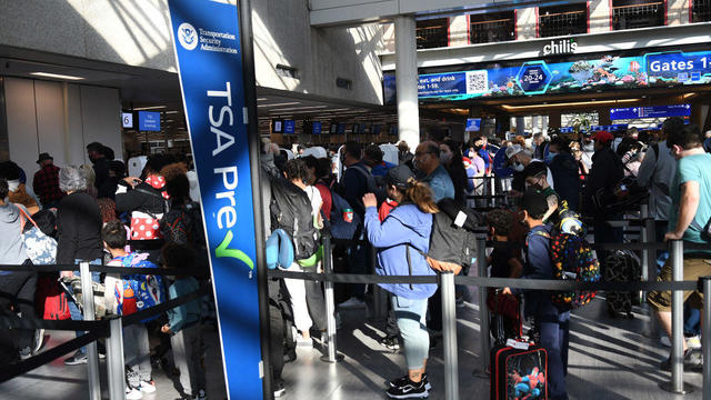 People are seen in a TSA security checkpoint line at Orlando 