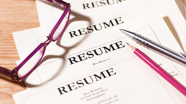 Pile of resumes with glasses and pen. 