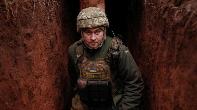 Ukrainian service member walks along a trench at a position on the front line near the city of Novoluhanske 