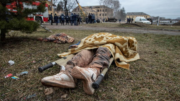 The body of a person lies on the ground next to a military base building that, according to the Ukrainian ground forces, was destroyed by an air strike, in the Sumy region 