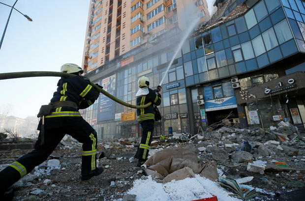 Firefighters extinguish fire in an apartment building damaged by recent shelling in Kyiv 