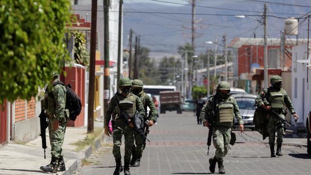 Members of the Mexican army walk near the house where nine people were killed in Atlixco 