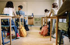 Multiracial group of students sitting at desk in classroom 