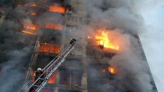 Rescuers work next to a residential building damaged by shelling in Kyiv 